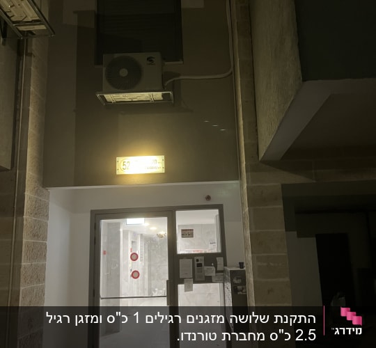 יחידת מיזוג אוויר מותקנת על קיר חיצוני בלילה